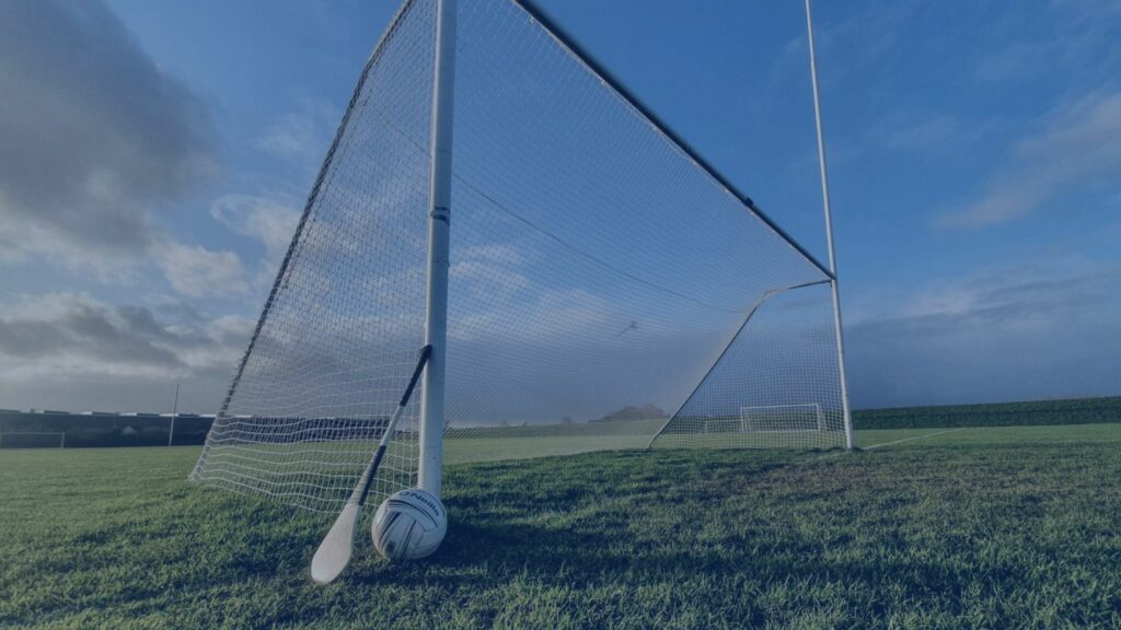 GAA field goalpost with Hurley and football.